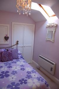 a bedroom with a bed and a chandelier at Tre-Allt Gorgeous Cottage in Dolgellau