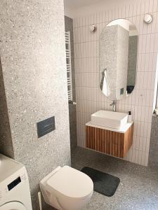 W łazience znajduje się toaleta, umywalka i lustro. w obiekcie Comfort apartment w Warszawie