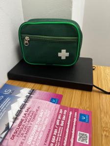 a green bag sitting on a table next to some books at Alojamiento Torrevieja playa frente al mar in Torrevieja