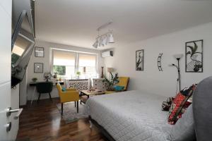 ein Schlafzimmer mit einem Bett und ein Wohnzimmer in der Unterkunft Olympiad Oasis in Sarajevo