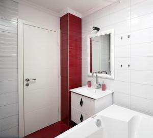 ein weißes Badezimmer mit einem Waschbecken und einem Spiegel in der Unterkunft Olympiad Oasis in Sarajevo
