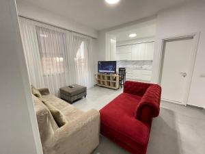 a living room with a couch and a red chair at Tirana AS Apartment 3 City Center in Tirana