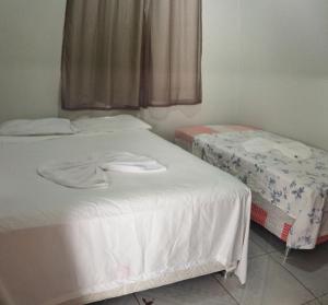 two beds in a room with towels on them at Apartamento Central Privativo in Boa Vista