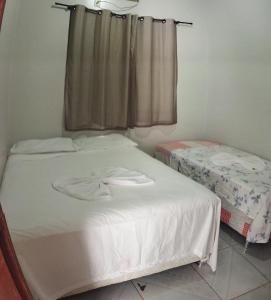 a bedroom with two beds and a window at Apartamento Central Privativo in Boa Vista