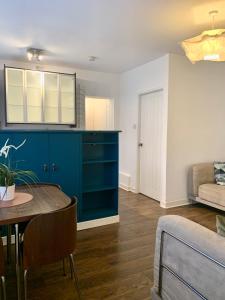 a living room with a blue cabinet and a table at DIDSBURY Fáilte Inn Apts - 3 Mins to The Christie's - Ground Floor - FREE Parking in Manchester
