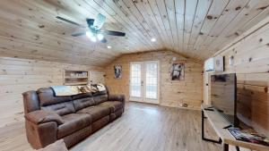 un soggiorno con divano e ventilatore a soffitto di Double L Ranch a Pigeon Forge