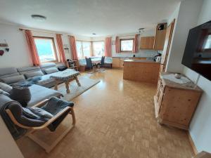 uma ampla sala de estar com um sofá e uma cozinha em Ferienhof PUA em Sent