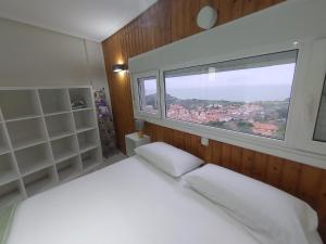 a bedroom with a white bed and a window at Torre de laredo 9-3 in Laredo