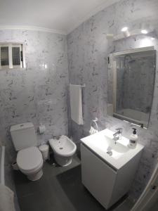 a white bathroom with a toilet and a sink at Torre de laredo 9-3 in Laredo +15 photos