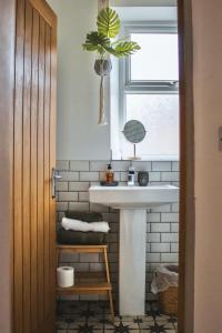 a bathroom with a white sink and a window at Spa Garden Cottage - Upper Hopton in Mirfield