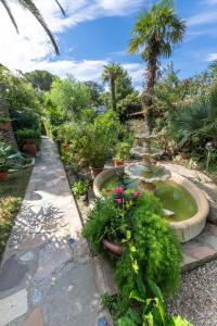 a garden with a fountain with plants and flowers at ***Villa Prestige**** in Capoliveri