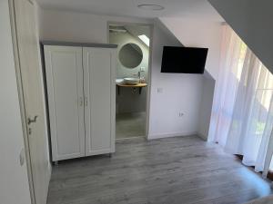 a room with a hallway with a door and a television at Casa Presecan in Tălmăcel