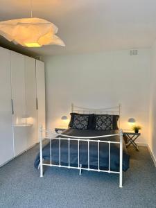 1 dormitorio con 1 cama en una habitación blanca en DIDSBURY Fáilte Inn Apts - 3 Mins to The Christie's - Ground Floor - FREE Parking en Mánchester