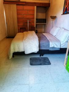 a bedroom with a bed and a rug on the floor at Hotel Marrokos Aeropuerto JMC in Rionegro