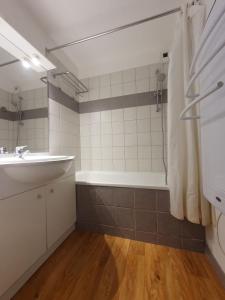 uma casa de banho com um lavatório, uma banheira e um chuveiro em Montagne Les Orres em Les Orres