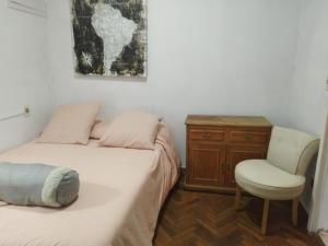 um quarto com uma cama, uma secretária e uma cadeira em Excelente ubicación!!! em Montevidéu