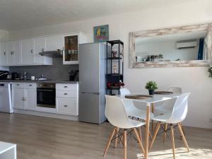 uma cozinha com uma mesa e cadeiras e um frigorífico em Appartement vue mer mont des oiseaux em Hyères