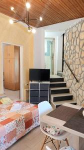 ein Schlafzimmer mit einem Bett und eine Treppe mit einem TV in der Unterkunft Apartment Kiwi in Rabac