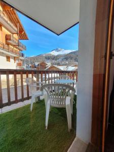 d'un balcon avec une table, des chaises et une montagne. dans l'établissement Montagne Les Orres, aux Orres