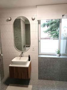 łazienka z umywalką, lustrem i oknem w obiekcie Comfort apartment w Warszawie