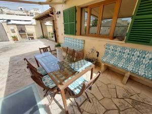 a patio with a table and chairs and a bench at Dau 39 in Montuiri