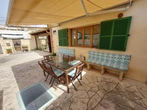 a patio with a table and chairs and a bench at Dau 39 in Montuiri