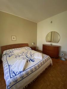 una camera da letto con un letto con un comò e uno specchio di Spazio Friuli - Soreli Apt residenza nel verde a Sevegliano