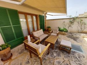 a patio with chairs and tables and green shutters at Dau 39 in Montuiri