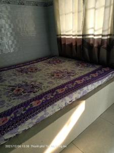 un letto in una stanza con un motivo floreale sopra di MOTEL MINH TÂM 28 