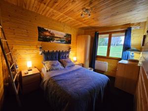 ブルボン・ランシーにあるGrand Chaletの木造キャビン内のベッド1台が備わるベッドルーム1室を利用します。