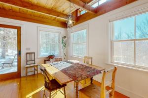 a dining room with a table and chairs and windows at Light-filled Retreat in Mad River Valley 