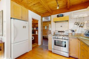 a kitchen with white appliances and wooden ceilings at Light-filled Retreat in Mad River Valley 