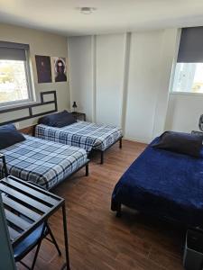 a room with three beds and a window at Hotel Sttiny Monterrey Tecnológico in Monterrey