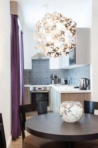 a kitchen with a table and a large chandelier at Seel Street Apartments by EPIC in Liverpool