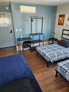 Habitación con 2 camas y espejo. en Hotel Sttiny Monterrey Tecnológico, en Monterrey