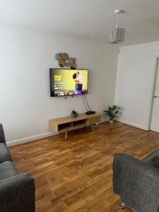 a living room with a flat screen tv on a wall at Manchester home near City Centre and City stadium in Manchester