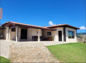 a small white house with a large driveway at Recanto NS Aparecida in Socorro