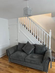 a living room with a couch under the stairs at Manchester home near City Centre and City stadium in Manchester