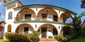 a large white building with arches and balconies at Bombon Guesthouse in Brisas de Zicatela