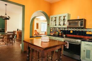 a kitchen with a table and a stove and a microwave at Bombon Guesthouse in Brisas de Zicatela