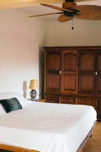 a bedroom with a bed and a ceiling fan at Bombon Guesthouse in Brisas de Zicatela