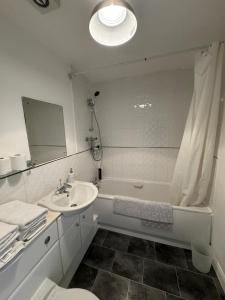uma casa de banho com um lavatório, uma banheira e um WC. em Manchester home near City Centre and City stadium em Manchester