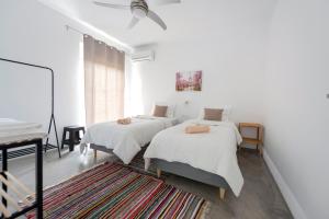 a bedroom with two beds and a ceiling fan at Ikiesnafplio in Nafplio