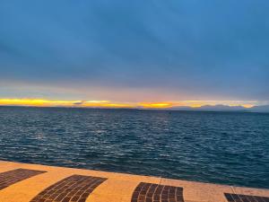 Blick auf einen großen Wasserkörper bei Sonnenuntergang in der Unterkunft Cangrande Hotel in Lazise