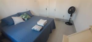 a blue bed in a room with a fan at Casa Celeste Búzios in Búzios