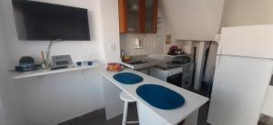 a small kitchen with a white refrigerator and a blue counter at Casa Celeste Búzios in Búzios