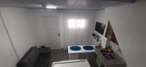 a white bathroom with a toilet and a television at Casa Celeste Búzios in Búzios
