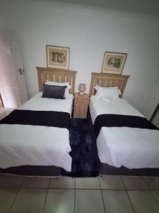 dos camas sentadas una al lado de la otra en una habitación en TT’s self-catering apartments, en Qumbu