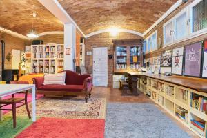 a library with a couch and a table and books at Loft Art Studio Sant Cugat - Barcelona in Sant Cugat del Vallès