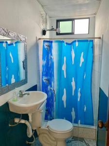 baño con aseo y cortina de ducha azul en Suite Vista Al Mar, Costa Piura, en Montañita